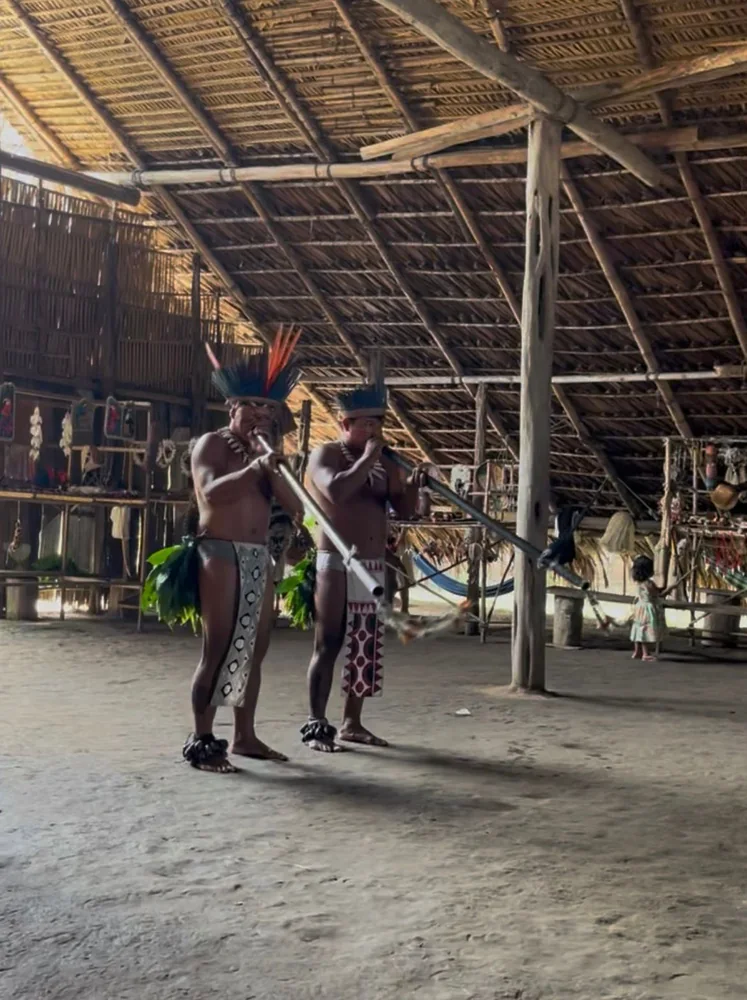 Apresentação cultural indígena no interior de uma oca